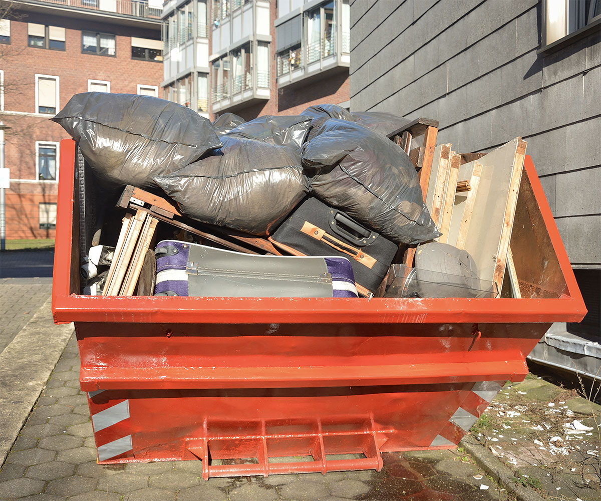 Ein Container mit Entrümpelungsmüll in rotorange