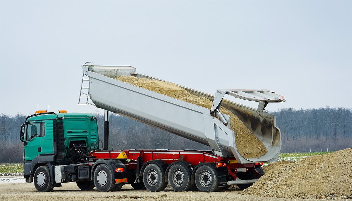 Großer Sattelkipper der Sand auf den Boden abkippt